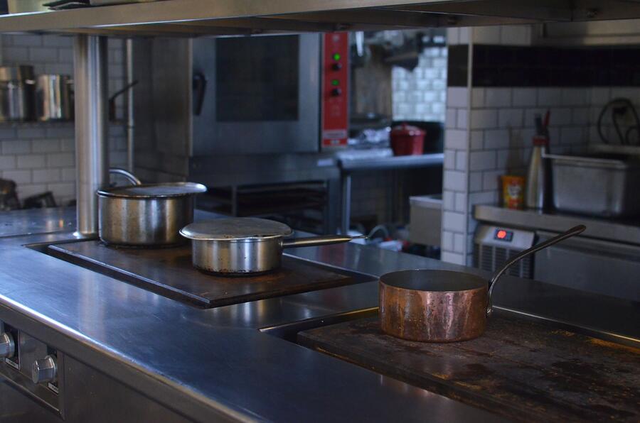 The stainless steel line of a working restaurant kitchen