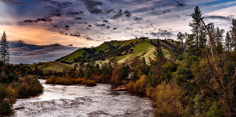 A river cutting through oak-covered hills